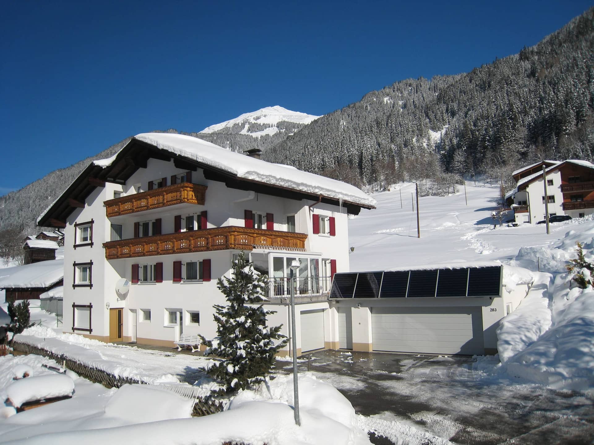 Ferienhaus Lerch im Winter, tief verschneit vor den Bergen