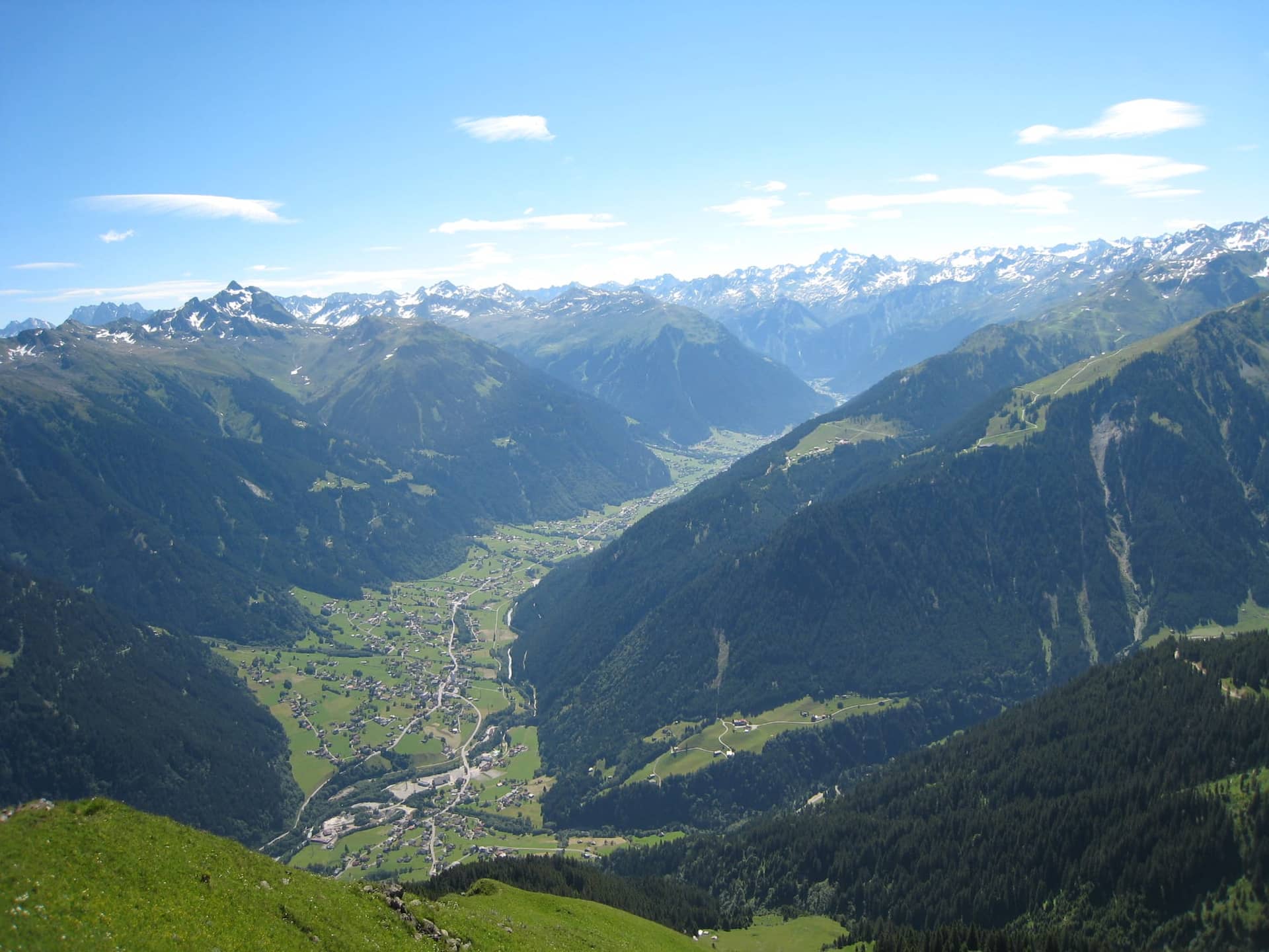 Blick über das Montafon im Sommer mit grünen Wiesen und Bergen
